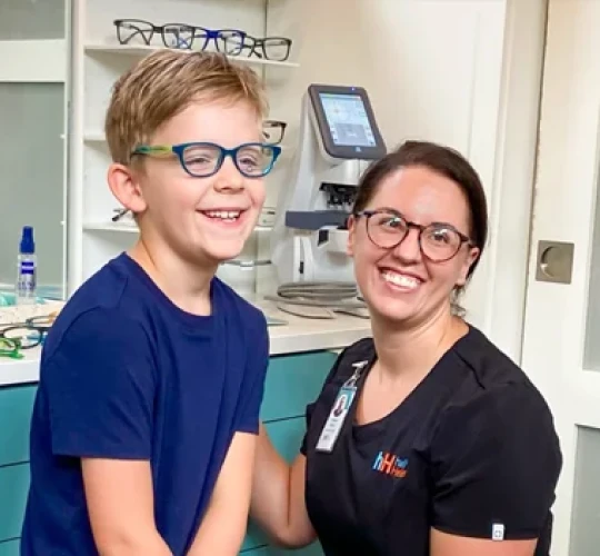 Woman and small child smiling in a eye clinic