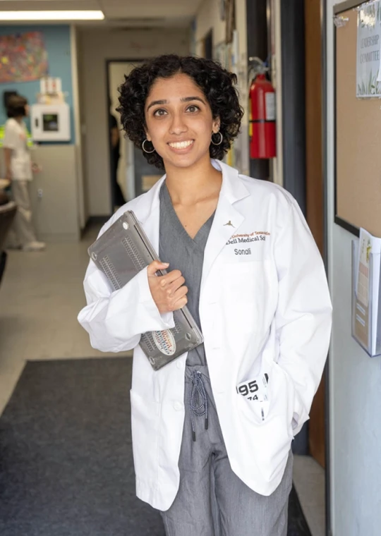 Healthcare professional standing inside a clinic smiling