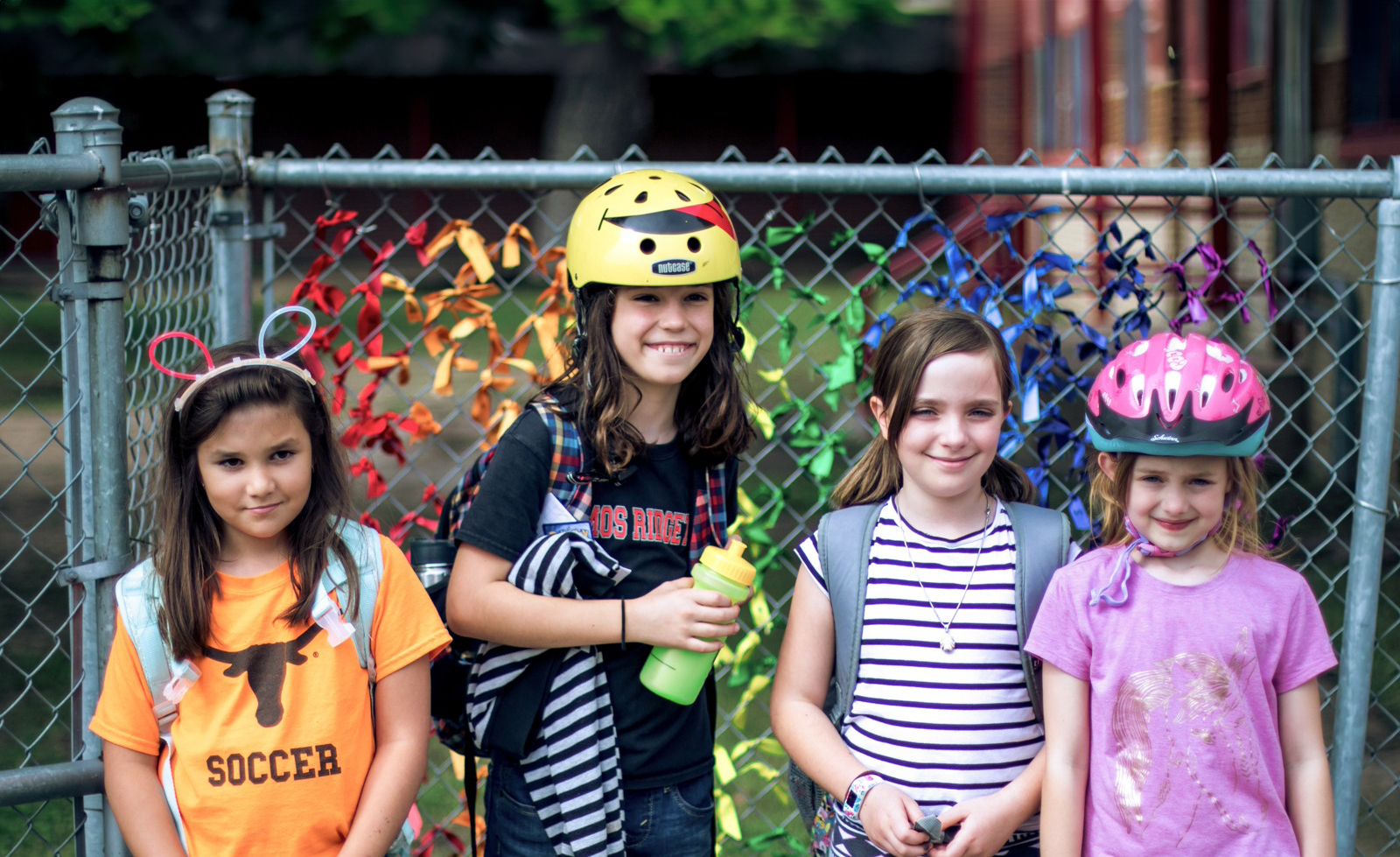 Group of 4 children standing side by side smiling