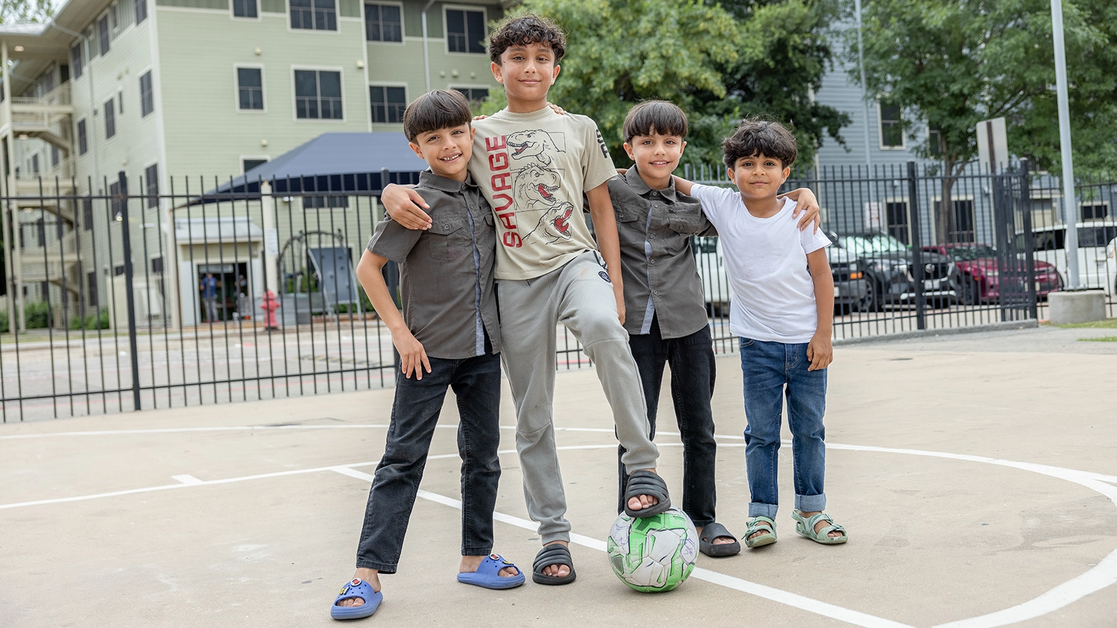 Four children play outside of their Foundation Communities apartment.