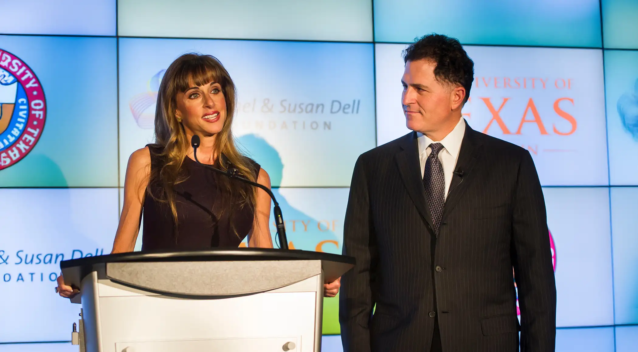 Michael and Susan speaking on stage at an event.