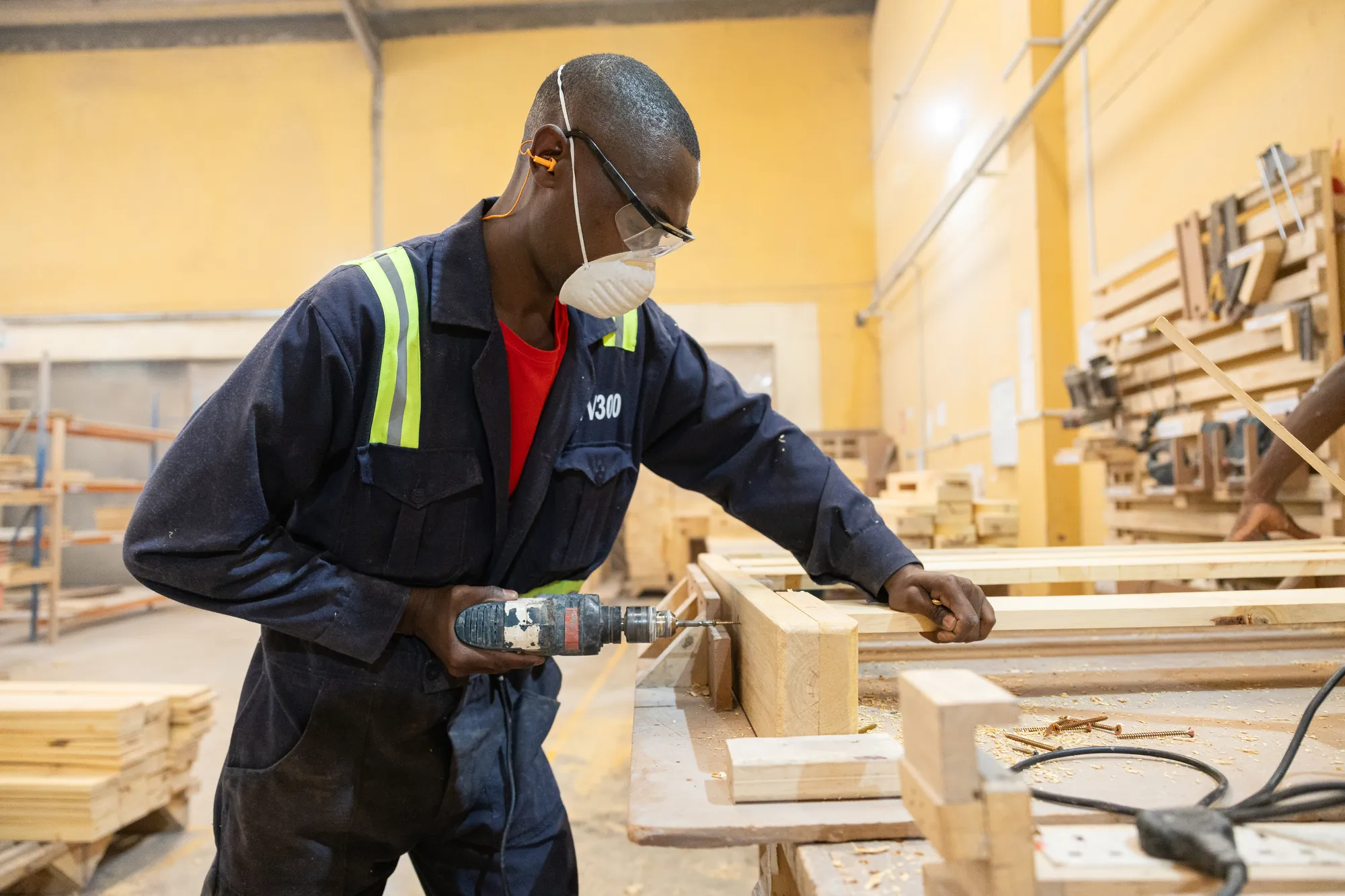 A Moko team member builds furniture in their factory.