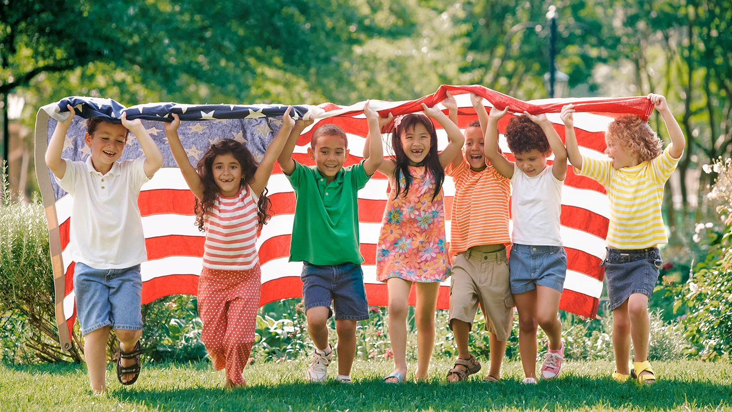 A group of children carry an American flag.